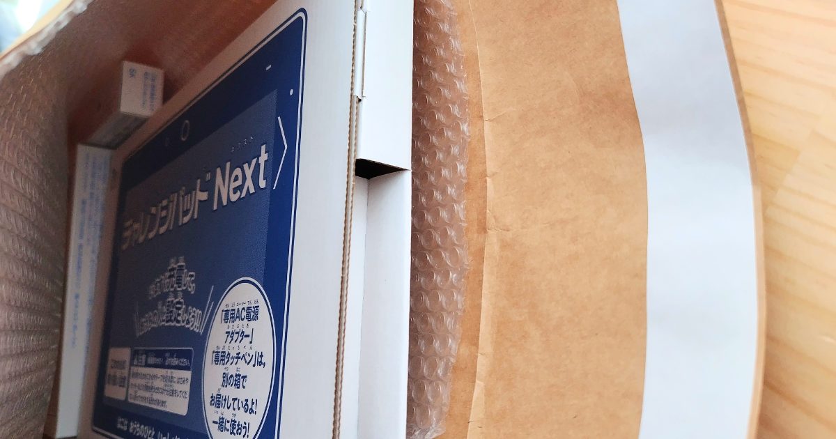 チャレンジタッチのタブレット、充電ケーブル、タッチペンを梱包した写真。