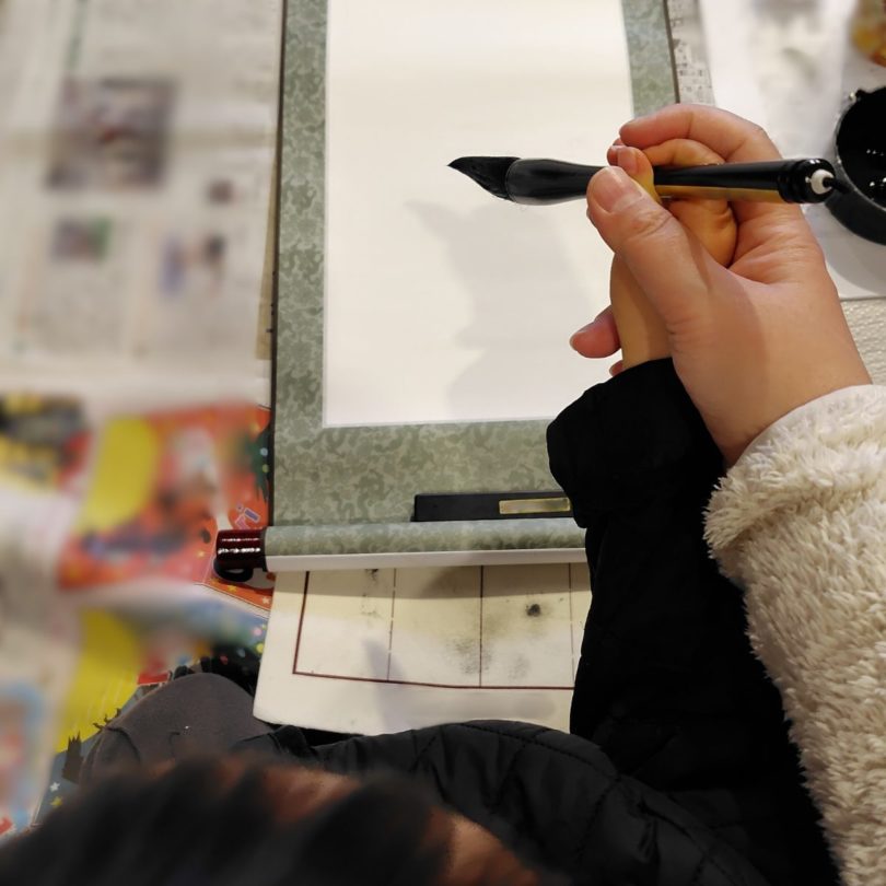 書初めで母と息子でこれから書くところの写真